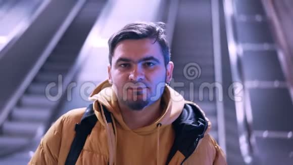 站在地铁车站扶梯楼梯背景上的年轻人画像有胡子的正经男人视频的预览图