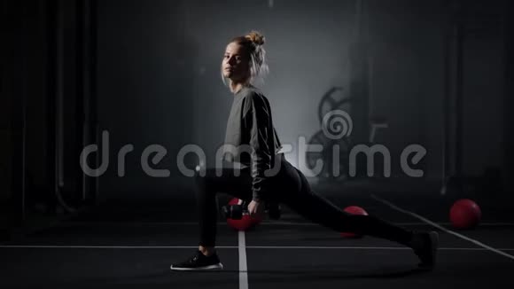 有性倾向的年轻女子在现代健身房用哑铃做步训练腿部视频的预览图