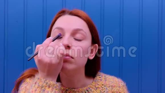 女人化妆年轻女人用化妆刷在脸上脸红化妆品概念视频的预览图