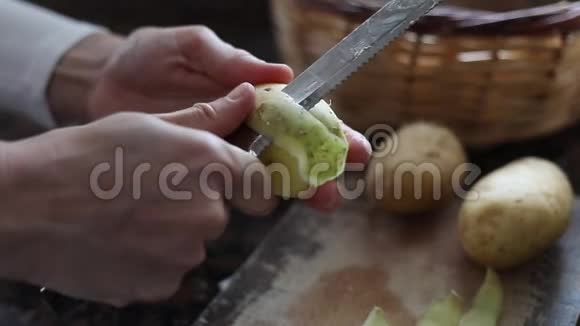 厨房里一个女人用白色背景的削皮机剥土豆视频的预览图