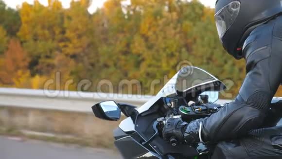 在秋天的乡间小路上骑摩托车的人挤得满满的戴头盔的年轻人骑现代运动视频的预览图
