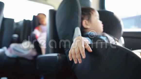 一个可爱的亚洲男孩睡在他的汽车座椅上以及他的兄弟姐妹的视频视频的预览图