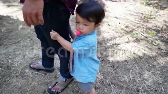 一个可爱的亚洲男孩在度假期间和家人玩耍的视频视频的预览图