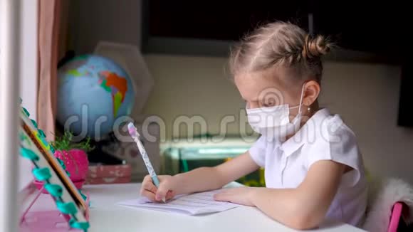 带防护面具的小女孩在远程家庭教育隔离视频的预览图