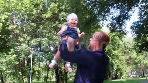 爸爸把女儿抛在空中走路时在城市公园里捉到视频的预览图