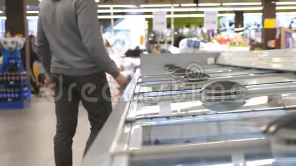 带医用口罩的男士在超市冷藏区打开玻璃门选择冷藏食品视频的预览图