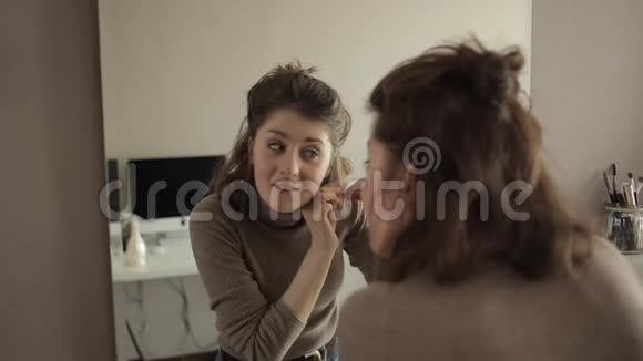 镜子前的一个年轻女孩检查她的头发抽出灰色的头发视频的预览图
