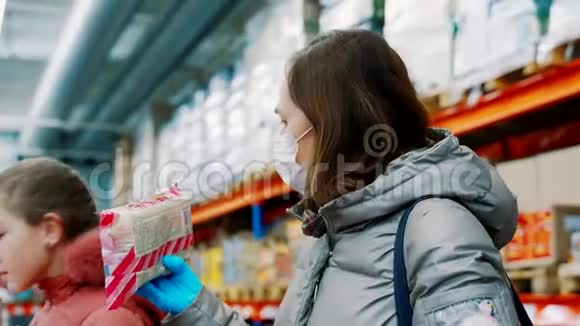 有女儿的女人在批发杂货店挑选产品穿冬装的女人戴医用口罩视频的预览图