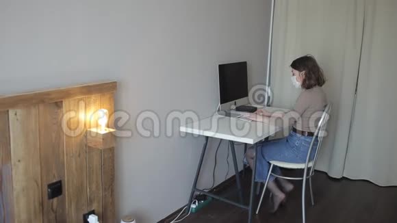 一个年轻女孩在隔离期间在房间里的电脑上工作然后做肩部按摩冠状病毒COVID视频的预览图