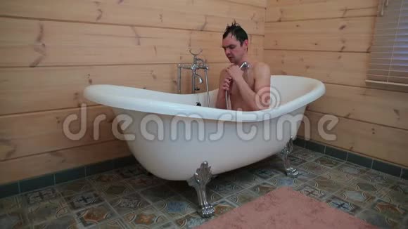 一个男人坐在浴室里洗身体做舞蹈动作视频的预览图