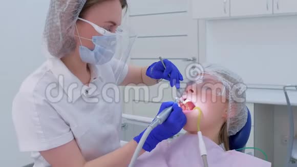 牙医清洁刷牙和抛光妇女牙齿使用钻头在牙科视频的预览图