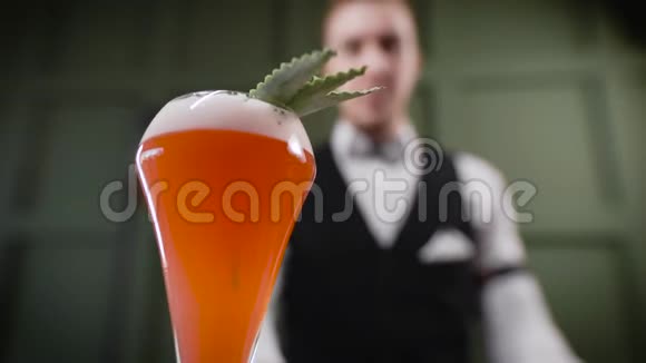 鸡尾酒已经准备好了酒保给顾客带了一杯设计精美的饮料酒精有助于娱乐视频的预览图