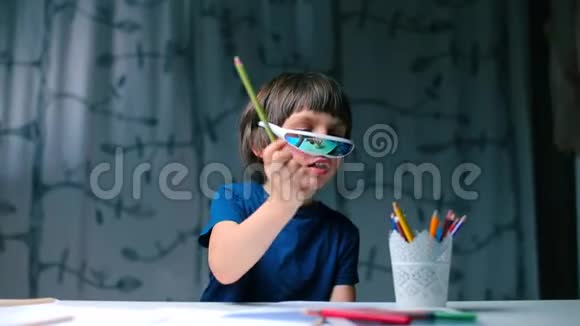 坐在桌子旁戴眼镜的男孩用铅笔砰砰地一声视频的预览图