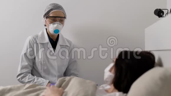 医生旁边有个重病的女人病毒感染无处不在病人戴着防护面罩视频的预览图