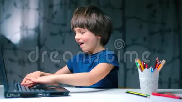 男孩用手轻敲笔记本电脑键盘视频的预览图