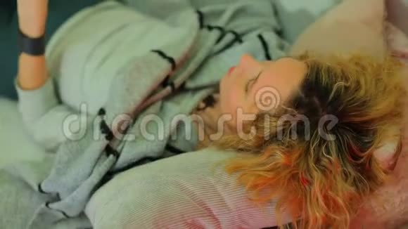 一个放松的女孩躺在沙发上双手放在头发上视频的预览图
