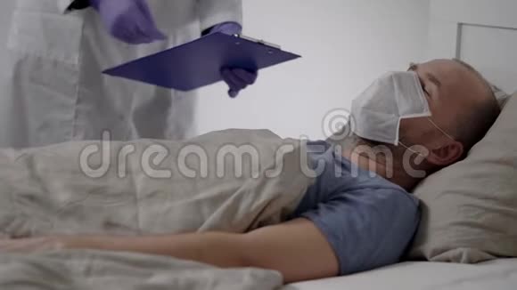 男病人因发烧而颤抖躺在医院的房间里医生正在握住他的手和身体视频的预览图
