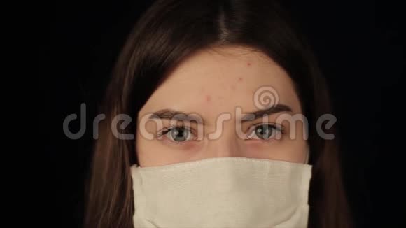 漂亮眼睛的女孩看着相机戴着医疗面具冠状病毒COVID19视频的预览图