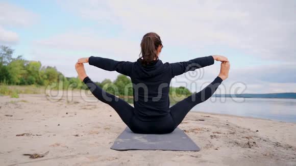 向上坐的广角姿势一个长角姿势的女孩坐在海滩上视频的预览图