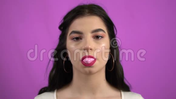 肖像嬉戏的女孩吹泡泡口香糖慢动作紫色视频的预览图