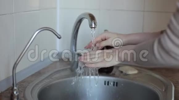 一个年轻女孩在水龙头下洗手特写镜头冠状病毒COVID19视频的预览图