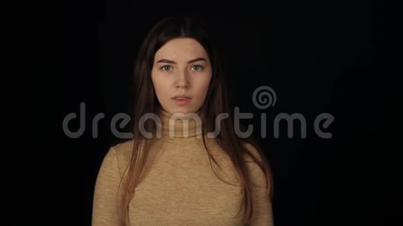 一位年轻的白人妇女咳嗽着微笑着孤立的黑色背景冠状病毒COVID19视频的预览图
