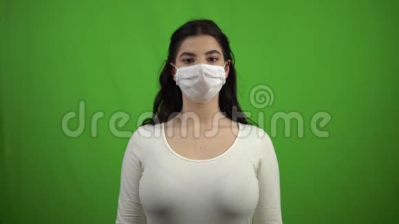 绿色屏幕上戴医疗面具的女孩冠状病毒COVID19大流行视频的预览图