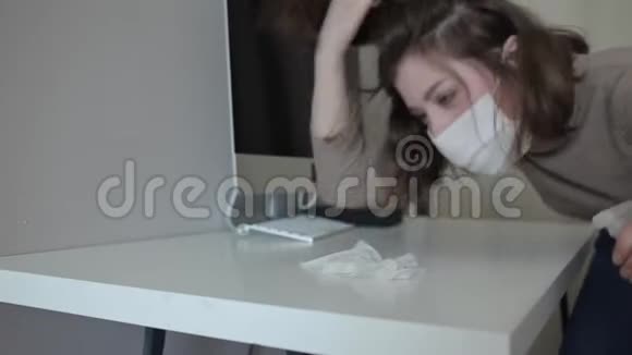 一个被隔离的保护性蒙面年轻妇女在家里培育桌面消毒冠状病毒COVID19视频的预览图