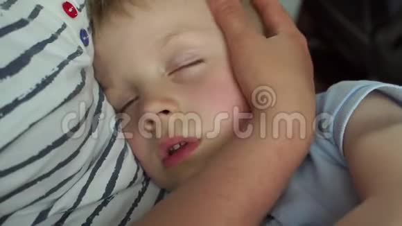 一个小男孩在旅途中汽车或公共汽车里抱着妈妈睡觉特写镜头视频的预览图