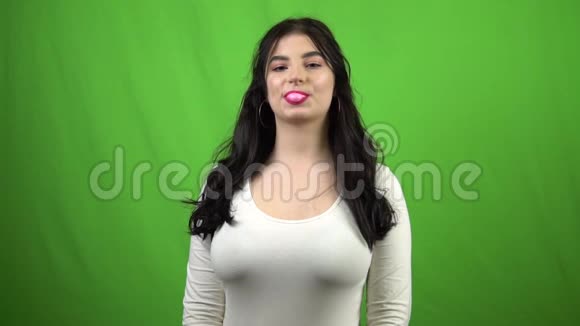 女孩嚼口香糖吹泡泡糖绿色屏幕慢动作4x视频的预览图