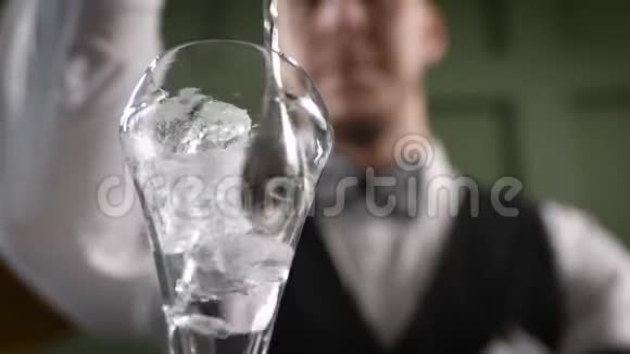 酒保把杯子凉了一个男人在鸡尾酒杯里干扰冰块视频的预览图