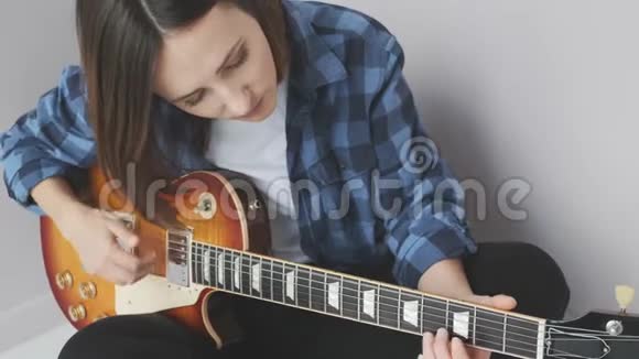 年轻迷人的女性在音乐会前用电吉他练习歌曲双手弹奏吉他拨弦拨弦视频的预览图