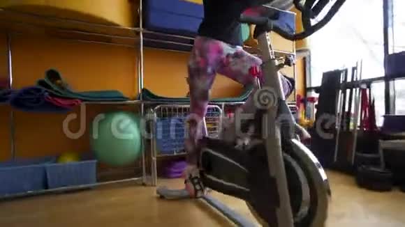 青年妇女团体一起在健身房骑自行车视频的预览图