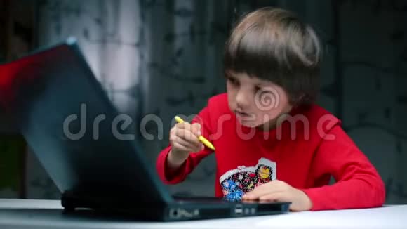 这个男孩用铅笔在笔记本显示器上画画视频的预览图