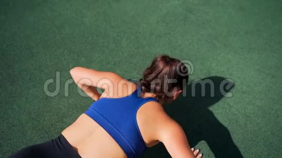 健身女孩做俯卧撑运动她正在围栏户外篮球场上健身视频的预览图