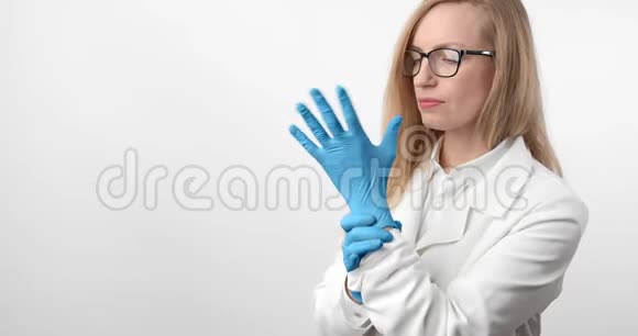戴实验衣和橡胶手套的女医生画像视频的预览图