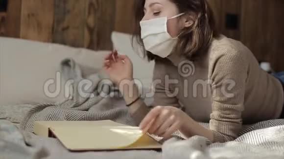 一个戴着保护面具躺着看书的年轻女孩的特写镜头冠状病毒COVID19视频的预览图