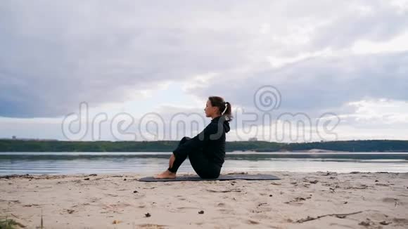 向上坐的广角姿势一个长角姿势的女孩坐在海滩上视频的预览图