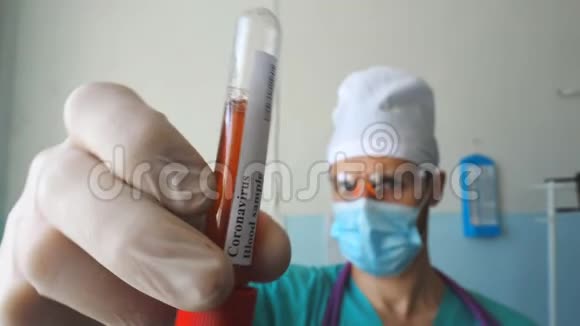 医生手拿着试管带血样到冠状病毒带防护手套检验血液的医生手臂视频的预览图