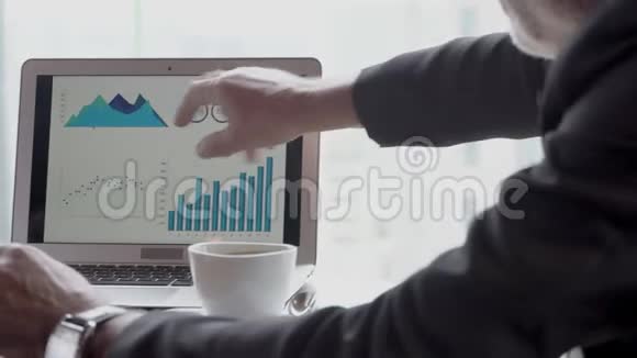 两位高级商人从办公室笔记本电脑上的统计图中规划目标财务视频的预览图