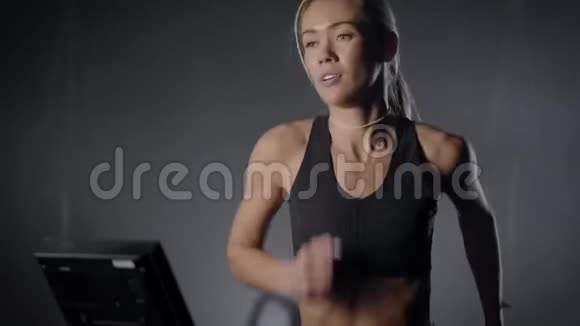 在健身房跑步机上滑溜溜的金发女郎一个身材漂亮身材紧绷的女孩在健身房跑步视频的预览图