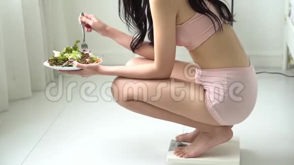 美丽的亚洲年轻女性穿着内衣身材完美早餐吃有机蔬菜和沙拉视频的预览图