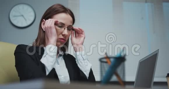 沮丧的年轻女性在办公室工作时闭着眼睛按摩鼻子青年视频的预览图