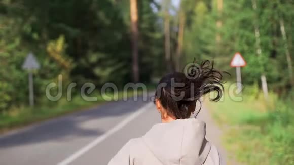 跑步的女人在公园里跑步在公园里的马路和街道上奔跑的女慢跑者跑步者做户外有氧运动视频的预览图