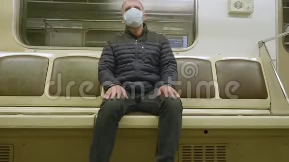 男子坐在移动地铁车厢的正面脸上戴着医疗面罩以保护自己免受感染视频的预览图