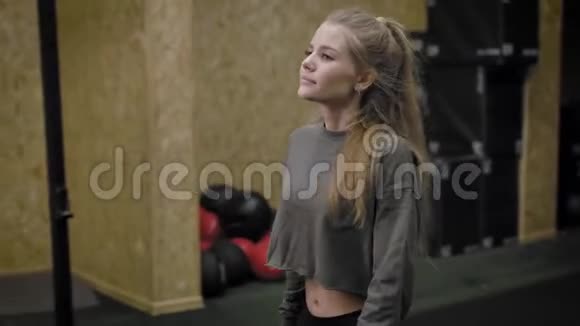 一个年轻漂亮的女人在健身房完成了她的教练金发女孩去喝水视频的预览图