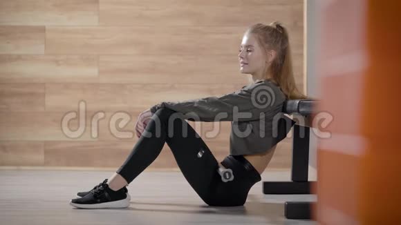 健身房里漂亮苗条的女孩一个年轻的女人在锻炼时放松视频的预览图