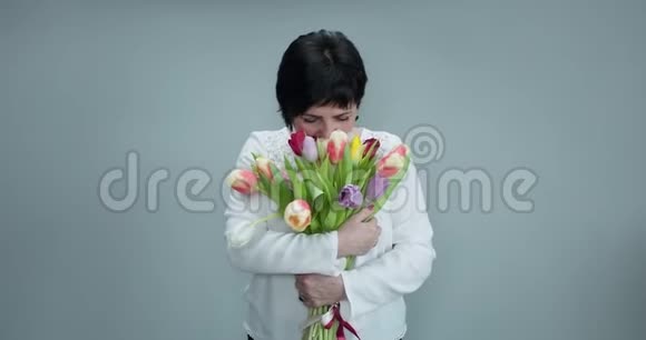 女人捧着郁金香对着镜头微笑美丽的女人在美丽的春天郁金香花束一群女人视频的预览图