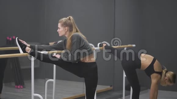 两个苗条的年轻女人做伸展运动在训练前伸展是非常重要的视频的预览图