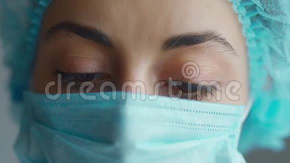 戴医疗帽和面罩的女医生或护士的极端特写面部和眼睛视频的预览图